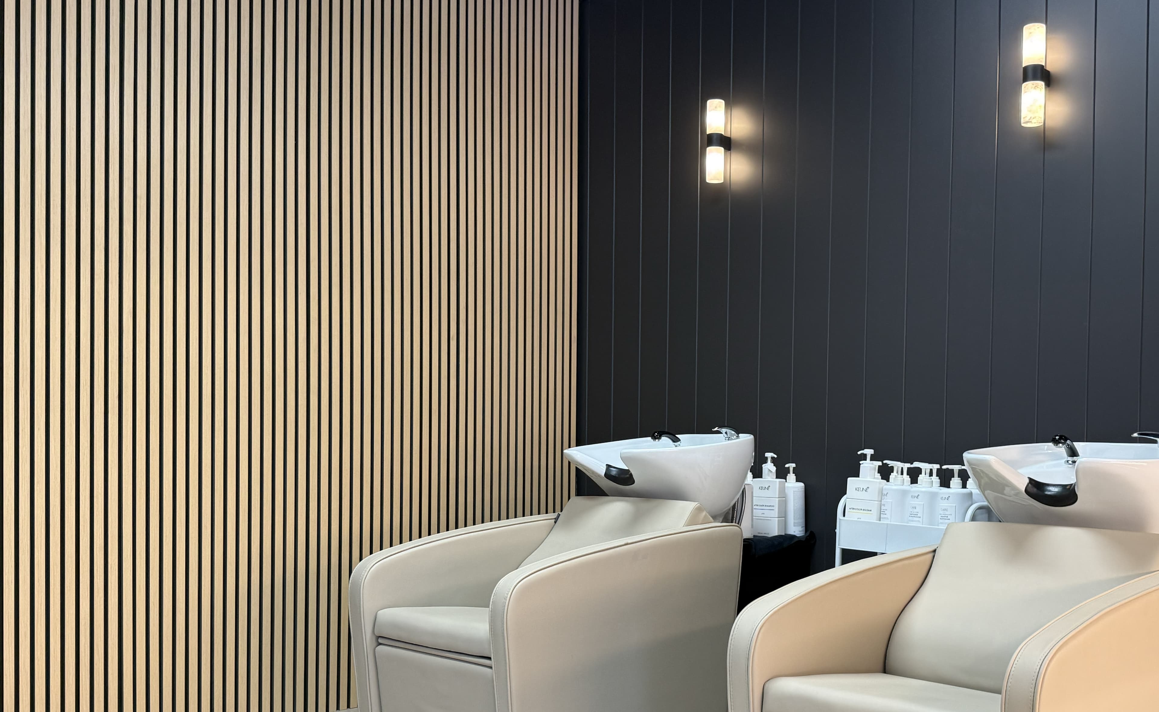 Hair wash stations with monument-colour cement cladding and natural oak slat panels at Elixir Aesthetic, East Perth